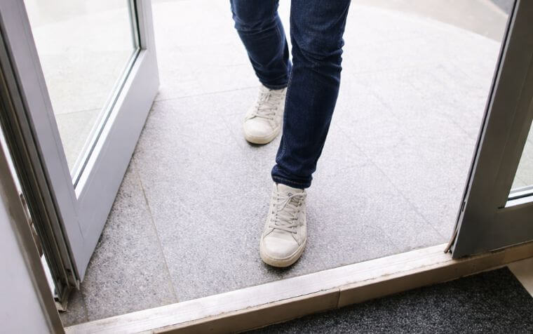 picture focused on the bottom half of a person walking through a door